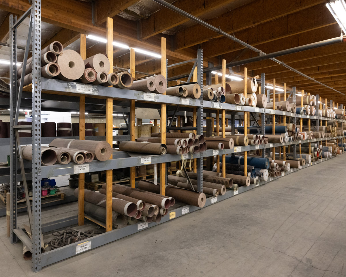 Image consists of rolls of bulk abrasives by jisco abrasives on storage racks